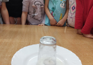 dzieci obserwują wessanie mleka pod szklankę